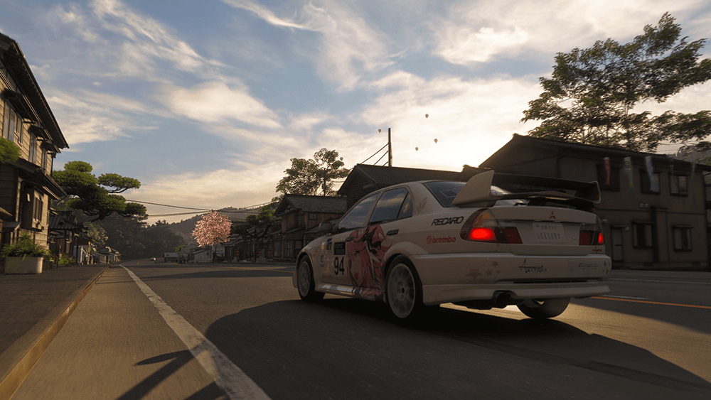 Forza Horizon 6 gameplay screenshot showing a Mitsubishi Lancer racing through a Japanese village street at golden hour