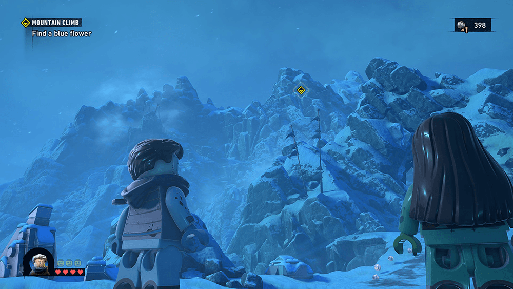 Lego Batman Legacy of the Dark Knight gameplay screenshot showing two Lego characters looking up at a snowy mountain during a Mountain Climb mission